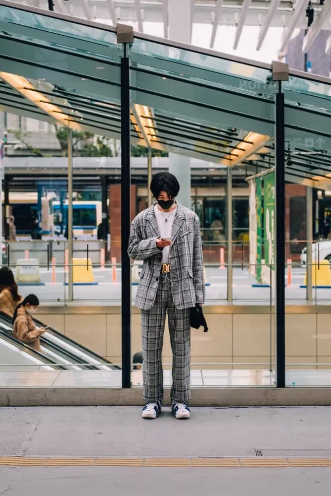 A man looking at his phone outside a train station