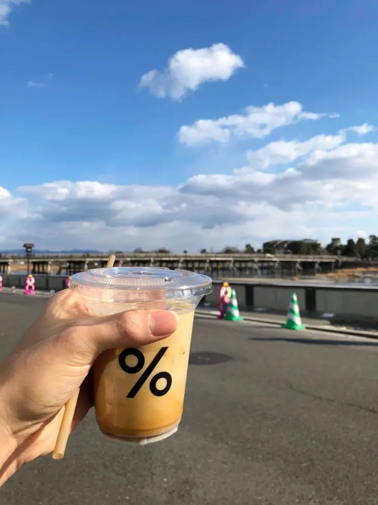 Kyoto Latte held up outside %Arabica in Arashiyama, Kyoto Prefecture