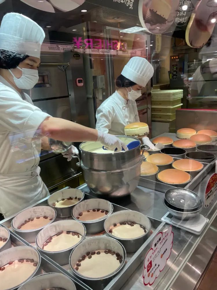 Chefs cooking cheesecake in an open kitchen at Rikuro's in Osaka, Osaka Prefecture