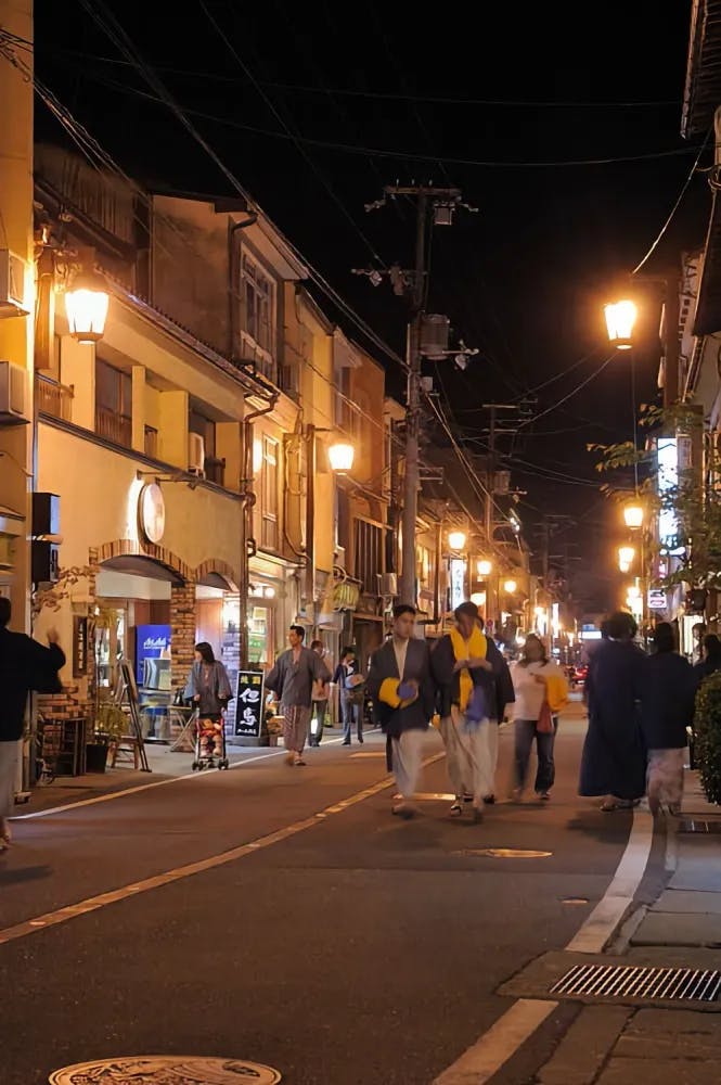 People in yukata walking along Yu-no-Sato Dori in Kinosaki Onsen, Hyogo Prefecture
